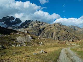 Fototapeta na wymiar The road to the mountain shelter against the background of a cloudy sky. Tour du Mont Blanc