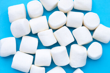 Delicious white marshmallows on blue background.