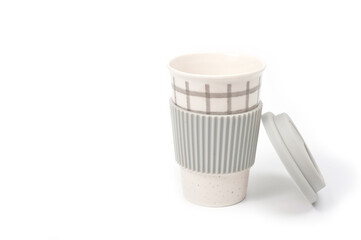 Checkered ceramic cup with rubber lid, shot against a white background.