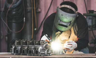 Highly skilled welders are welding a large number of sparks on the construction site in the factory.