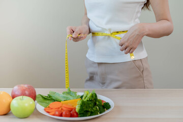 Slim shape asian young woman, girl standing, hand in measure tape around waist, body her have a...
