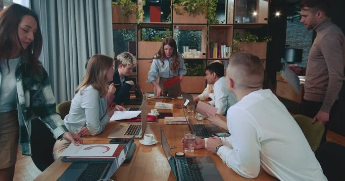 BUSINESS TEAM MEETING Successful female boss, company manager leading workplace meeting with group of happy colleagues.