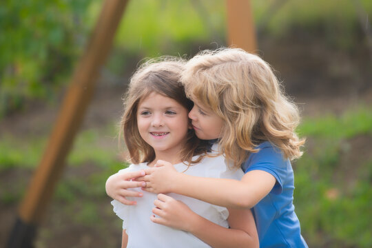 Little boy hugging shy girl, toddler boy embracing depressed little girl, relationship, friendship concept. Hugging kids outdoor. Lovely children. First love.