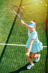 High angle image of a girl practicing serve on a brand new outdoor tennis court