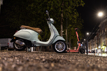 motocycle in the middle of the night under a street lamp standing in rain