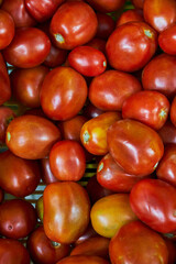 Tomatoes in a box placed on a shelf for sale in a market