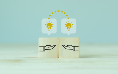 Knowledge and ideas sharing between two people ideas icon on wooden cube. Transferring knowledge,...