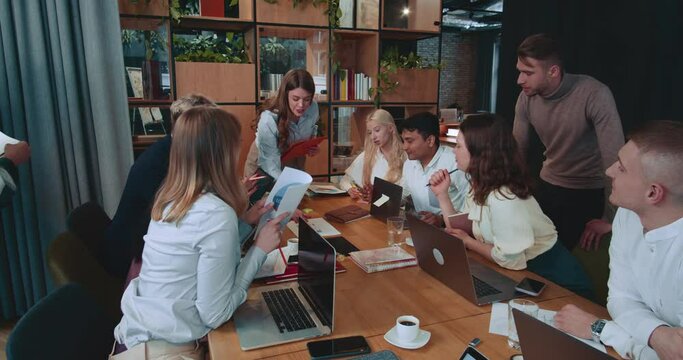 Beautiful happy successful young female boss, executive manager leads marketing presentation to office team slow motion.