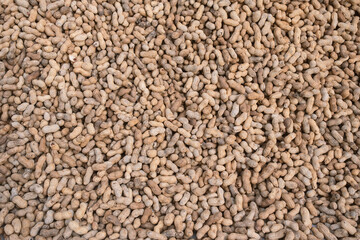 Background of unpeeled peanuts in the shell. Top view of the scattered nuts.