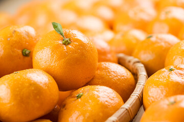 Fresh mandarin oranges fruit or tangerines with leaves in a bowl