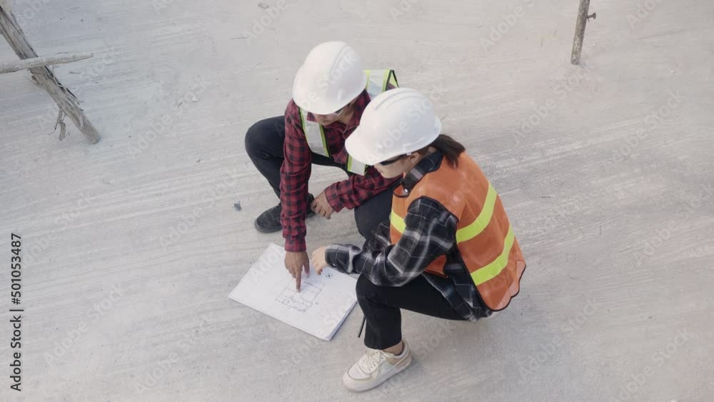 Poster architect and client discuss help create plan with blueprint of the building at construction site fl
