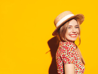 Portrait of young beautiful smiling blond female in trendy summer clothes. carefree woman posing near yellow wall in studio. Positive model having fun indoors. Cheerful and happy. In hat