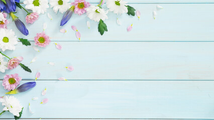Light blue wooden background with delicate flowers