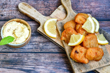   Allasca Pollock Fish  Bites in a crispy Tempura  Batter.Fish and chips .Close up of   crispy breaded  deep fried fish fingers with breadcrumbs s erved with remoulade sauce and  lemon