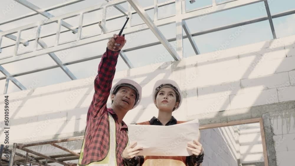 Poster architect and client discussing the plan with blueprint of the building at construction site