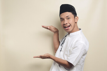 Portrait of young Asian Muslim man showing big size with his hands. isolated background