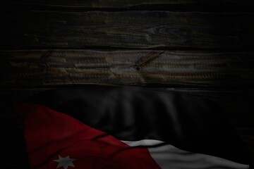 beautiful dark photo of Jordan flag with large folds on old wood with free space for your content - any occasion flag 3d illustration..