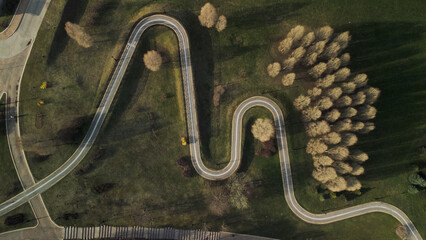 A winding bike path in a city park. Flight over the spring city park. Aerial photography.