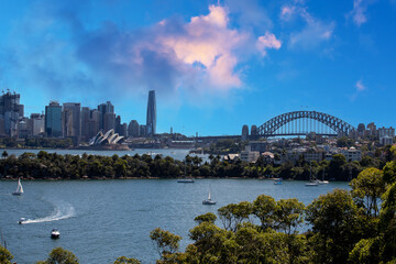 Naklejka premium Sydney Harbour Australia with nice colours in the sky. Nice blue water of the Harbour, high rise offices and residential buildings of the City in the background, NSW Australia
