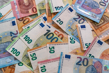 Fototapeta na wymiar Beautiful multicolored new euro banknotes scattered in a pile on a spacious table.