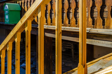 The stair railing is made of carved wooden boards.