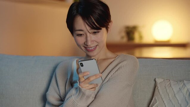 スマートフォンで動画を視聴する若い女性