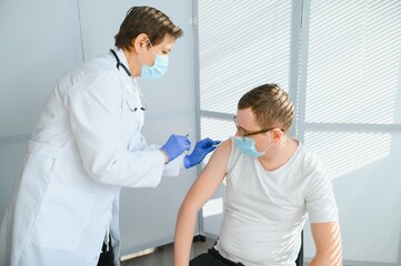 Fototapeta premium Female doctor vaccinating a man