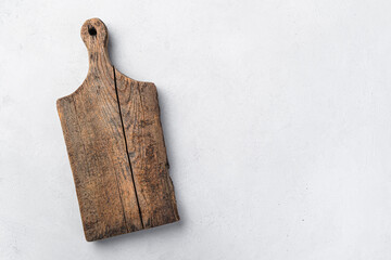 Vintage wooden cutting board on a gray background. Kitchen utensils. Top view, copy space.