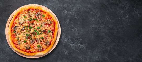 Pizza with mushrooms, cheese and tamatomi on a black background. Top view, copy space.