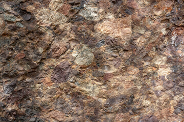 Geological section of rocky slab consisting of different stones. Horizontal.