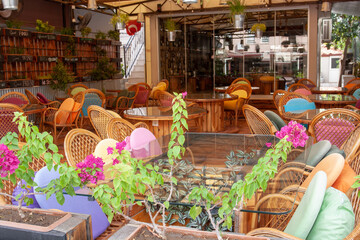 Cafe with glass tables and wicker chairs. Horizontal photo.