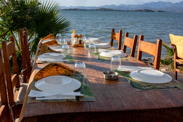 Served table in cafe by the sea with overturned plates and glasses.