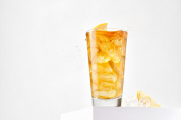 Delicious refreshing summer iced tea in a glass with grops. Sunshine. Copy space. Ice tea, cold lemonade with lemon