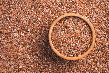 Flax seeds in a wooden bowl and on the background. Source omega 3. Top view, copy space.
