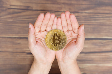 People Hand give and receive love of BTC Bitcoin on empty palm hands. Future of Crypto Currency will represent Heritage Gift to Family. Concept Love share with technology over wooden background - obrazy, fototapety, plakaty