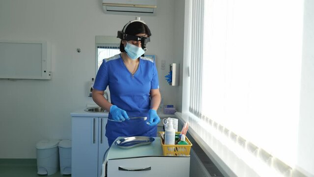 Young brunette woman doctor otolaryngologist. Woman doctor working with medical instruments
