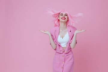 Pretty young female gesturing with hands pink jacket lifestyle glamor pink background unaltered