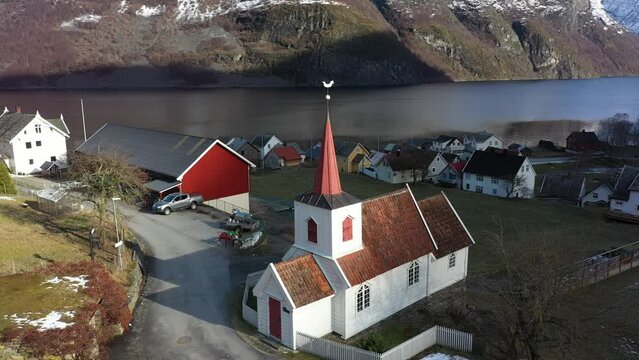Ancient Stave Church of Undredal along Aurlandsfjord in Norway - Aerial showing Europes smallest stavechurch during sunrise