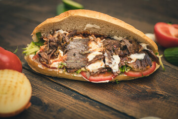 shawarma or doner with yogurt , tomatoes and herbs in a bun
