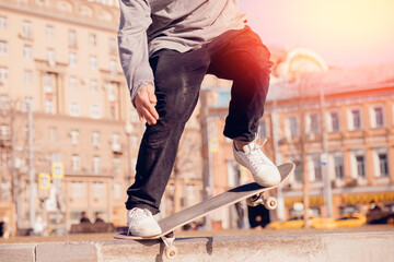 Man young skateboarder legs skateboarding skatepark on sunset. Concept tricks and jumping on skateboard