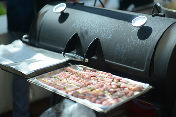chef grilling meat skewers at smoking barbecue outdoors in a garden