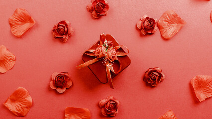 Red gift with petals falling down on the background