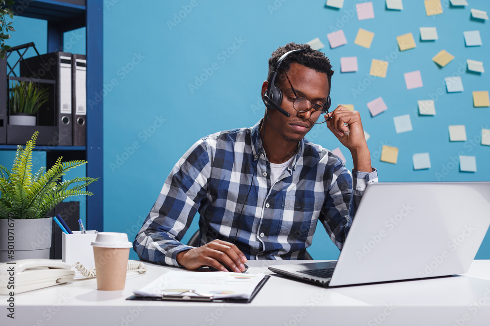 Poster stressed and fatigued telemarketer representative wearing headset while trying to help company clien
