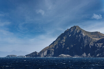 steep cliffs and sea at Cape Horn against blue sky