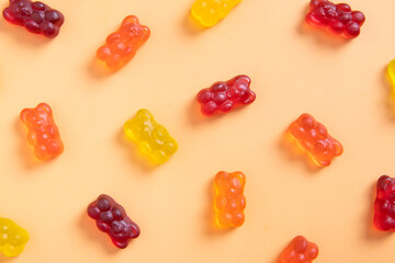 Colored jelly bears on an orange background. Top view