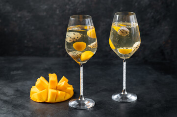 Dessert champagne jelly with exotic fruits - mango and pitahaya in a glass. On a black background