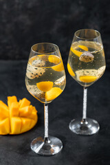Exotic dessert with mango and pitahaya - champagne jelly on black background.