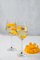 Dessert champagne jelly with exotic fruits - mango and pitahaya in a glass. On a white background