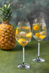 Dessert champagne jelly with exotic fruits - mango and pitahaya in a glass. On a black background