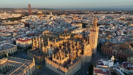 Gorgeous sunrise in Seville, Spain. Aerial shot of Seville city center with gothic cathedral and famous Giralda bell tower. - Powered by Adobe